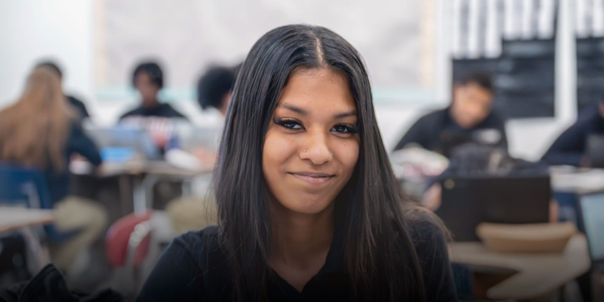 Smiling high school student in a classroom at Columbus Arts & Technology Academy.
