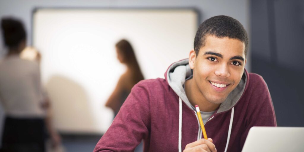 High School student smiling at a computer
